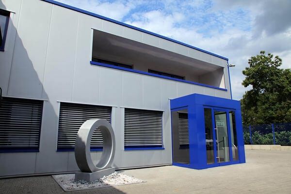 Ein Gebäude mit einer blauen Tür, das in einem klaren Himmel steht und eine einladende Atmosphäre ausstrahlt.