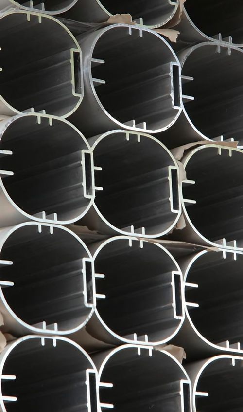 Mehrere Metallrohre sind übereinander gestapelt, was eine kompakte und geordnete Struktur darstellt.