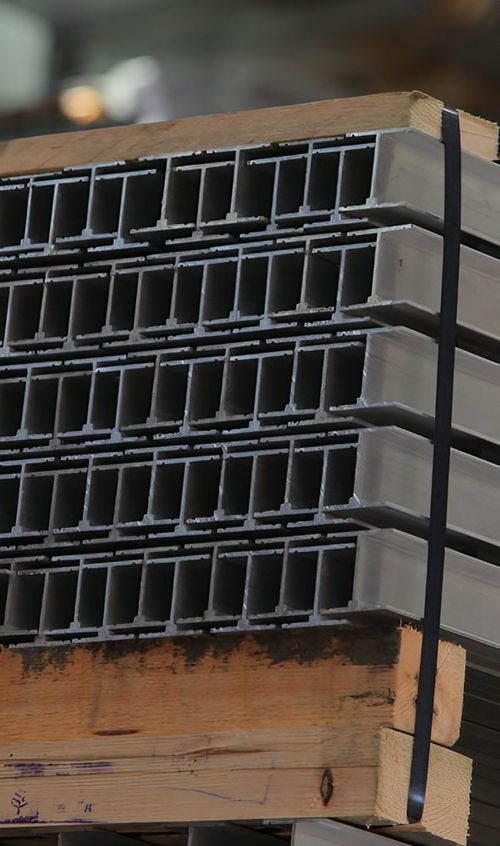 Eine Holzpalette trägt einen Stapel von Metallstangen, die sorgfältig gestapelt sind und auf Verwendung warten.