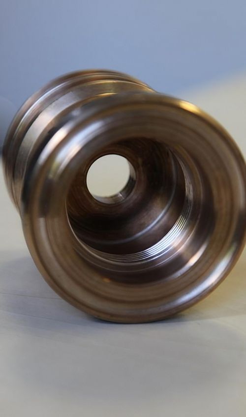 Nahaufnahme eines metallischen Objekts mit einem Loch in der Mitte, das die Struktur und Textur des Materials zeigt.